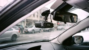 As part of this Hivemapper Review, a matte black Bee dashcam is mounted to a car windshield in a raw forensic style.