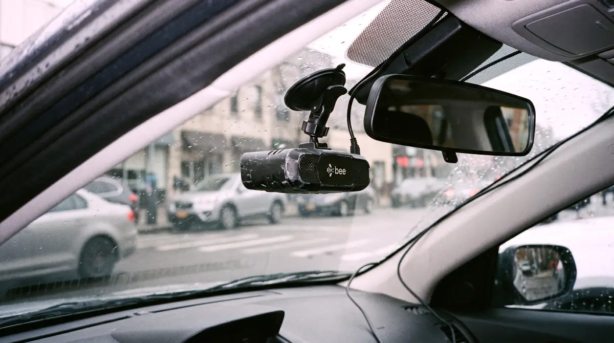 As part of this Hivemapper Review, a matte black Bee dashcam is mounted to a car windshield in a raw forensic style.