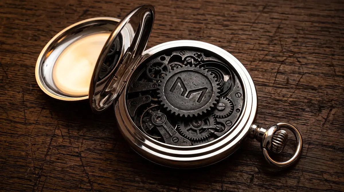Maker MKR Truth Cryptosmedia engraved on a heavy iron gear inside a disassembled pocket watch.